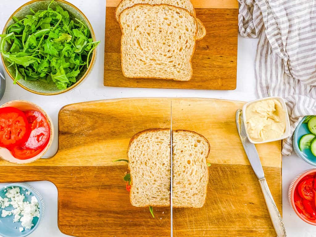 Sliced copycat panera mediterranean sandwich on a cutting board.