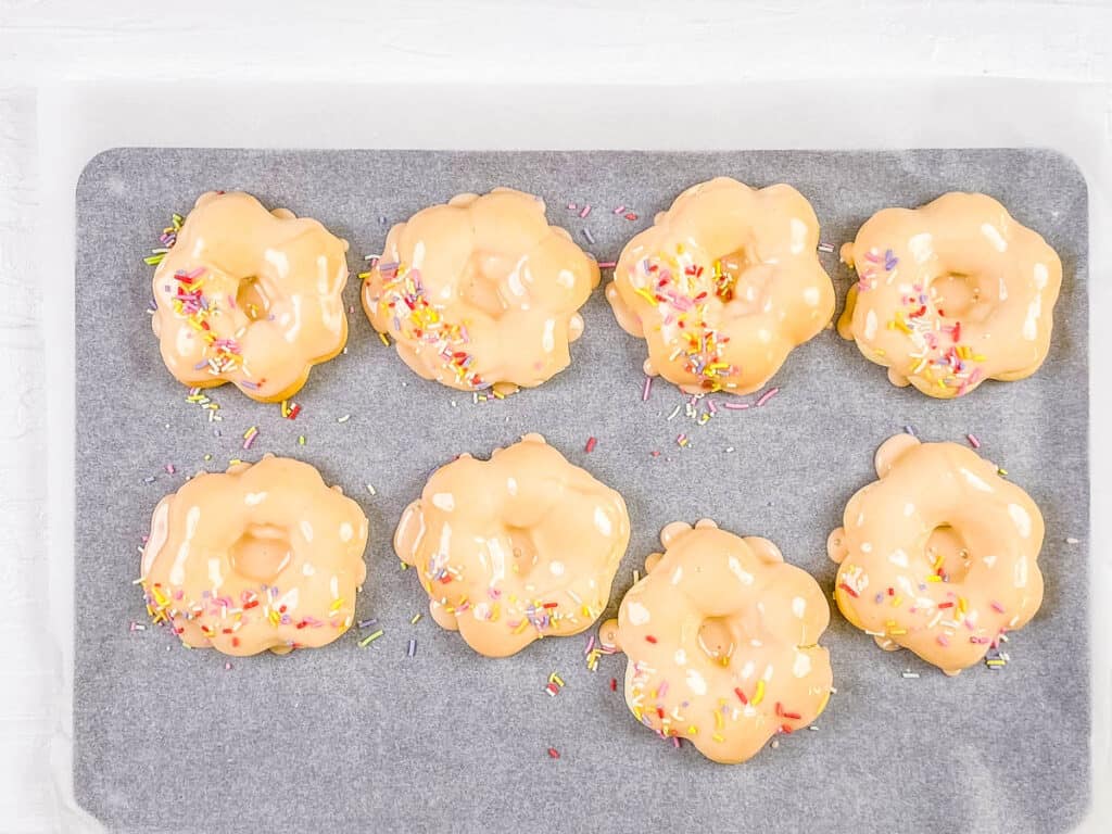 Iced donuts on a sheet pan.