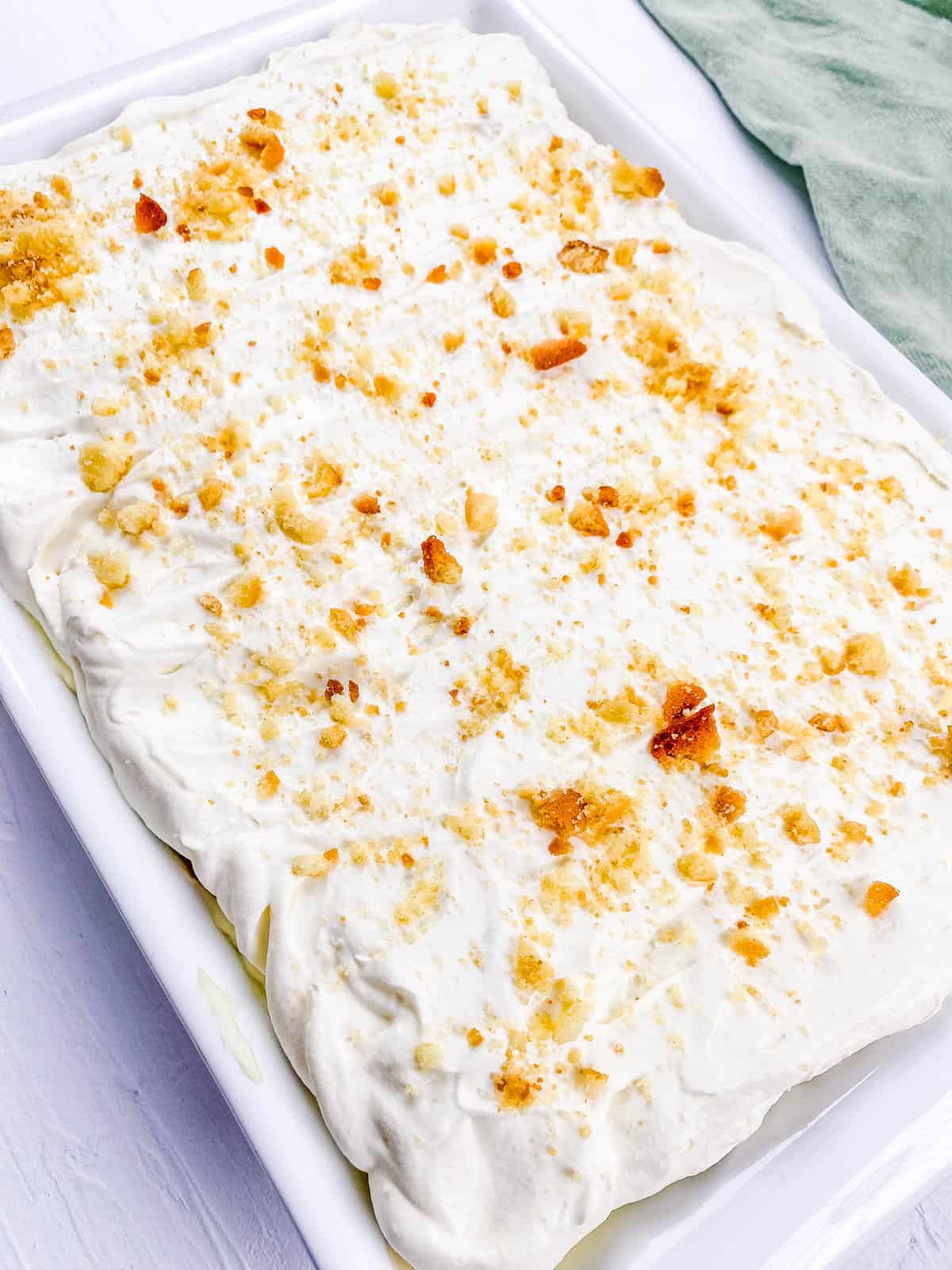 No bake banana pudding lasagna in a baking dish topped with crushed Nilla wafers.