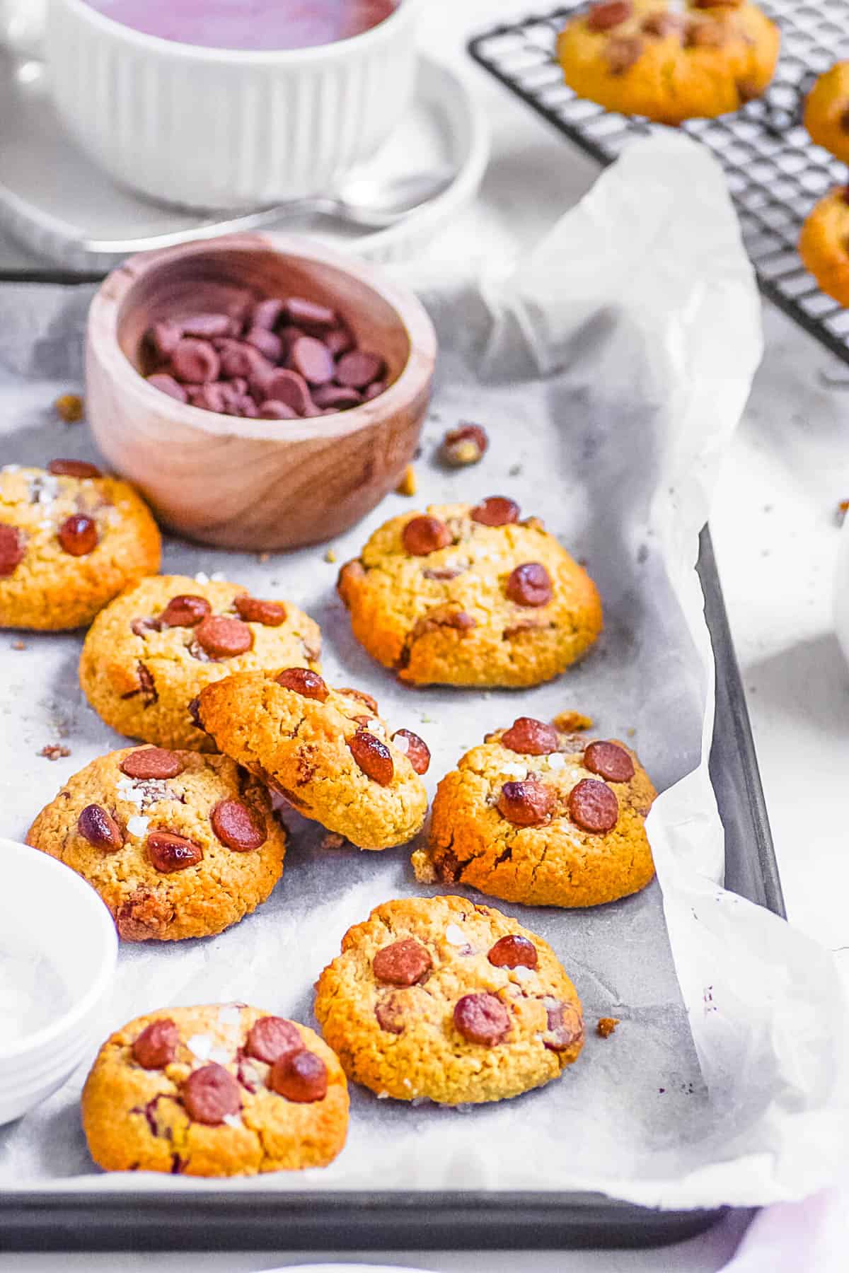 Oat flour chocolate chip cookies on a baking sheet lined with parchment paper.