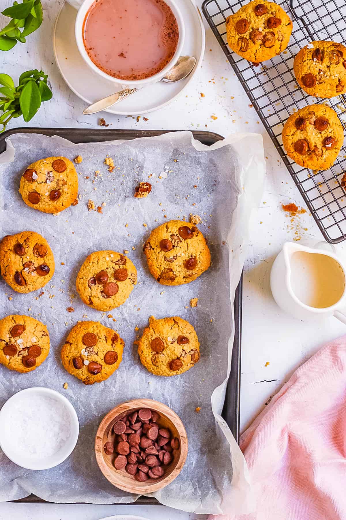 Baked oat flour chocolate chip cookies on a baking sheet lined with parchment paper.