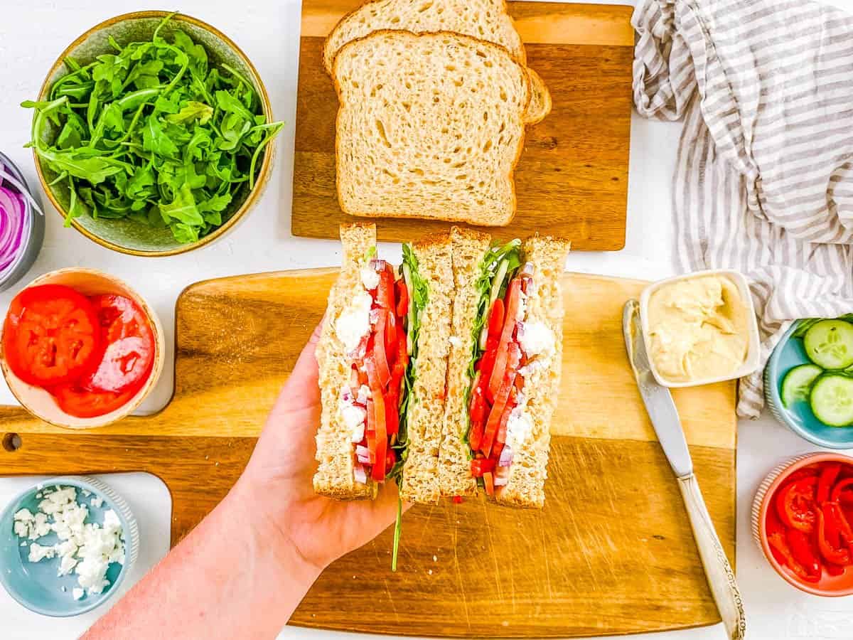 Sliced copycat panera mediterranean sandwich on a cutting board.