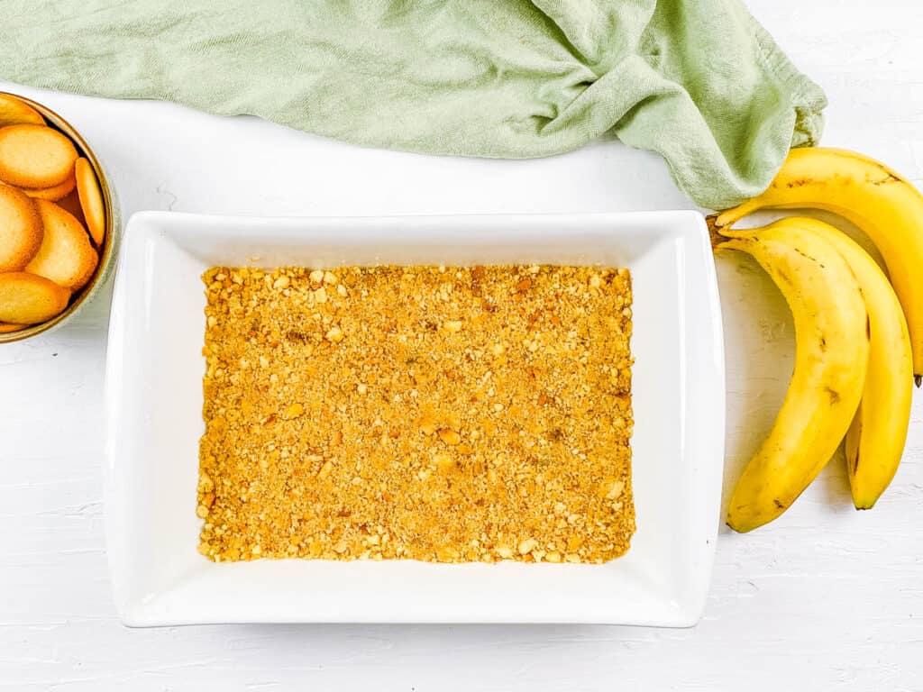 Crushed Nilla wafers pressed into a baking dish.