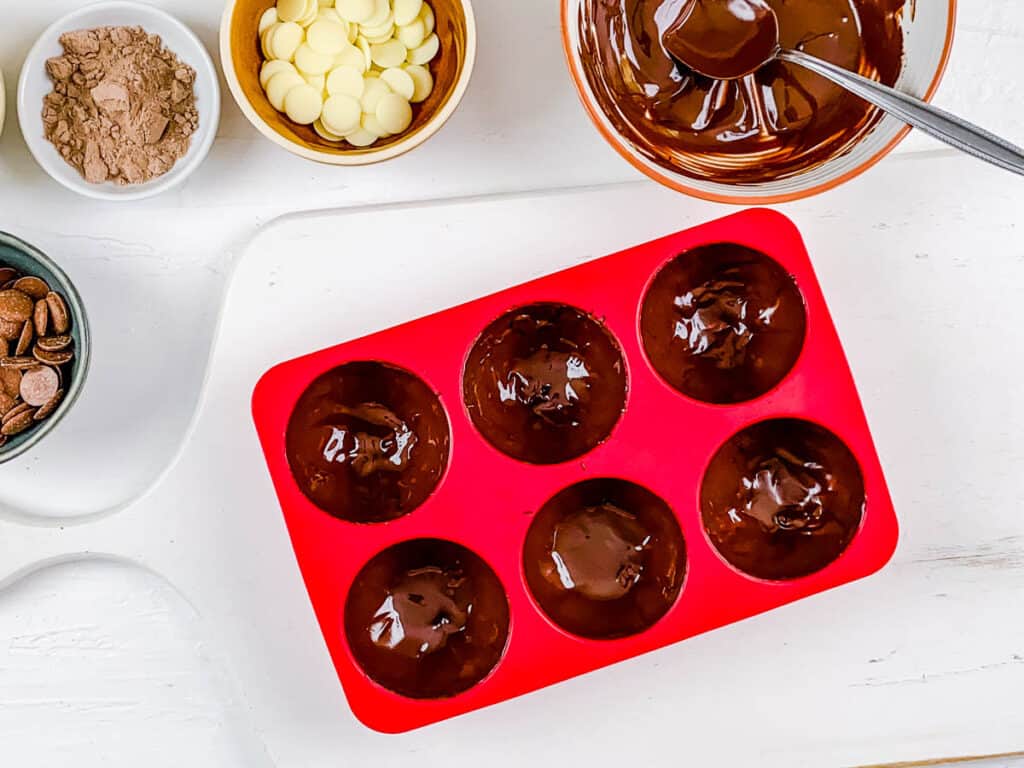 Boozy hot coca bomb shells in a silicone mold.