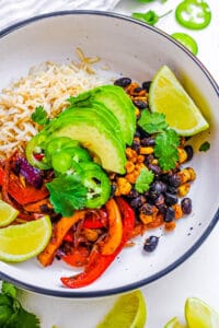 Healthy vegetarian fajita bowls with avocado and lime, on a white background.