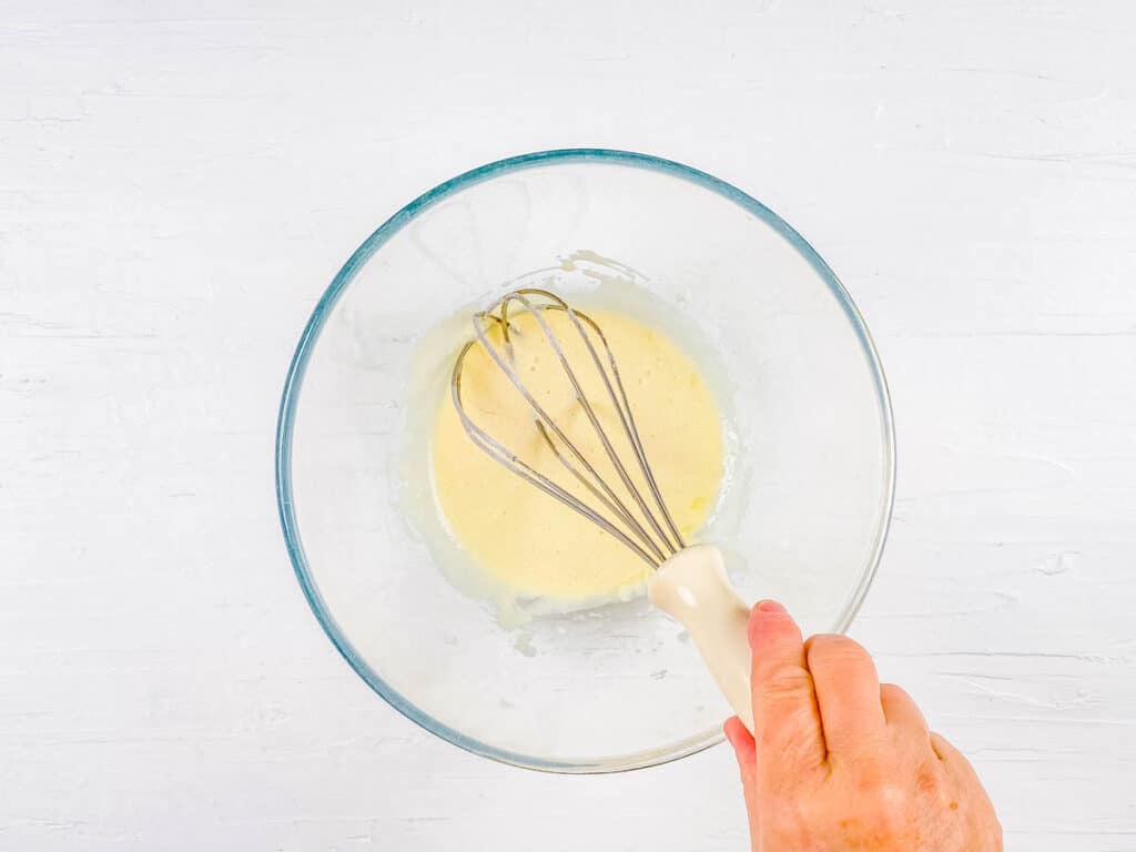 Wet ingredients for donut dough in a mixing bowl.