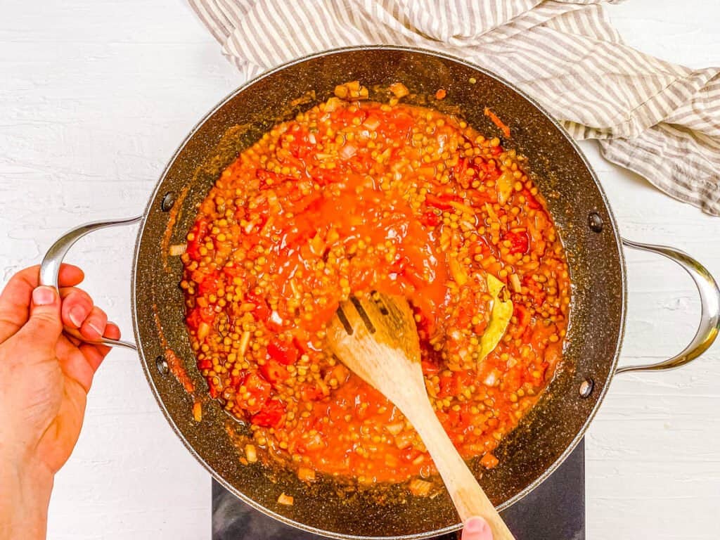 Lentil ragu cooking in a stock pot on the stove.