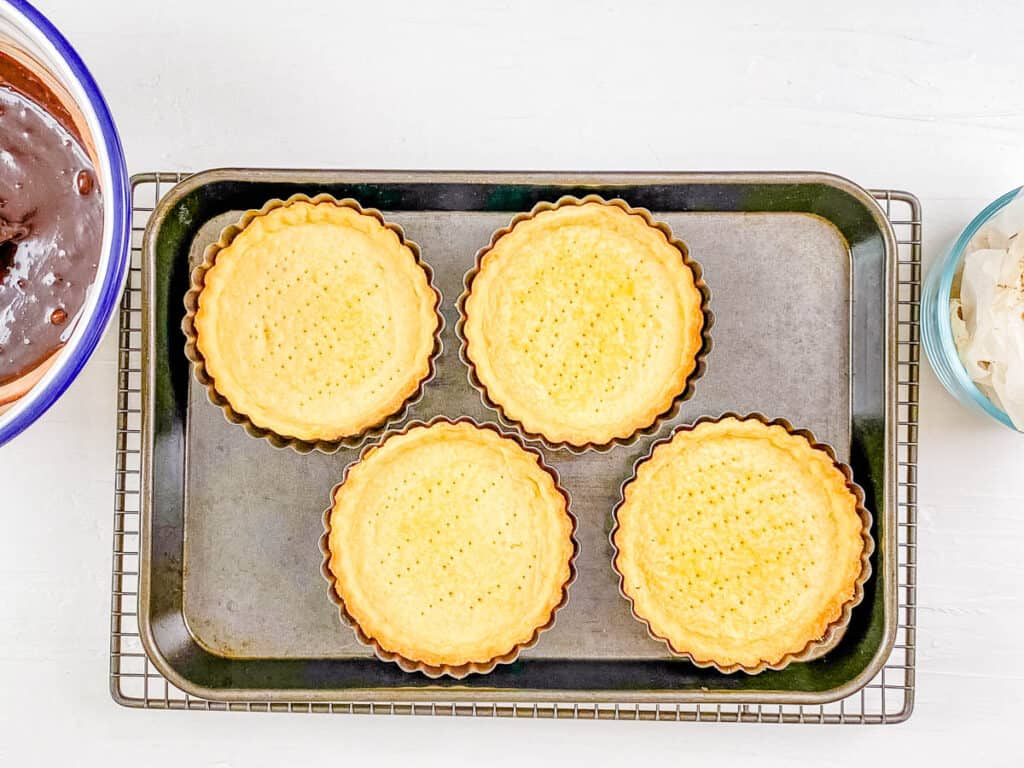 Chocolate mini tart shells baked in the oven.