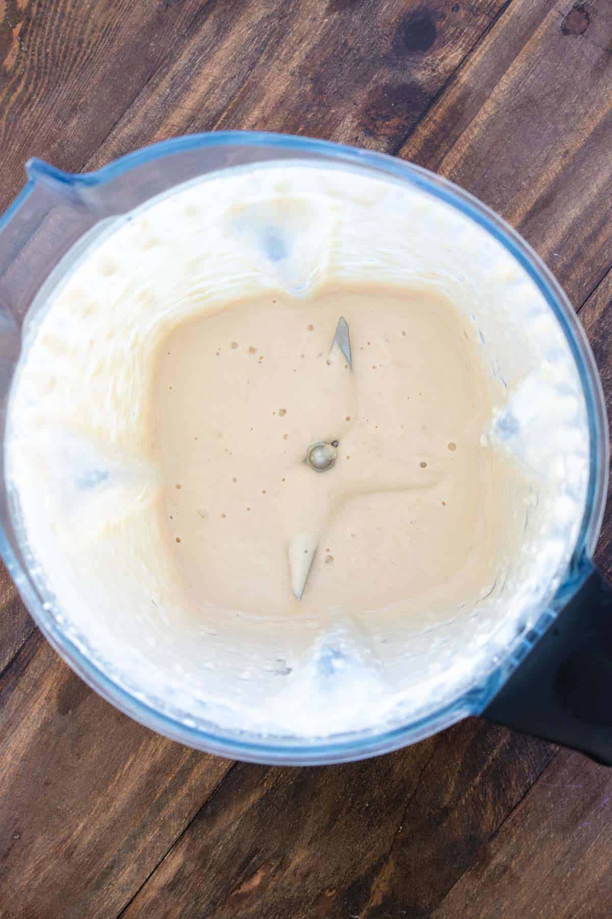 Top view of a blender with creamy sauce inside