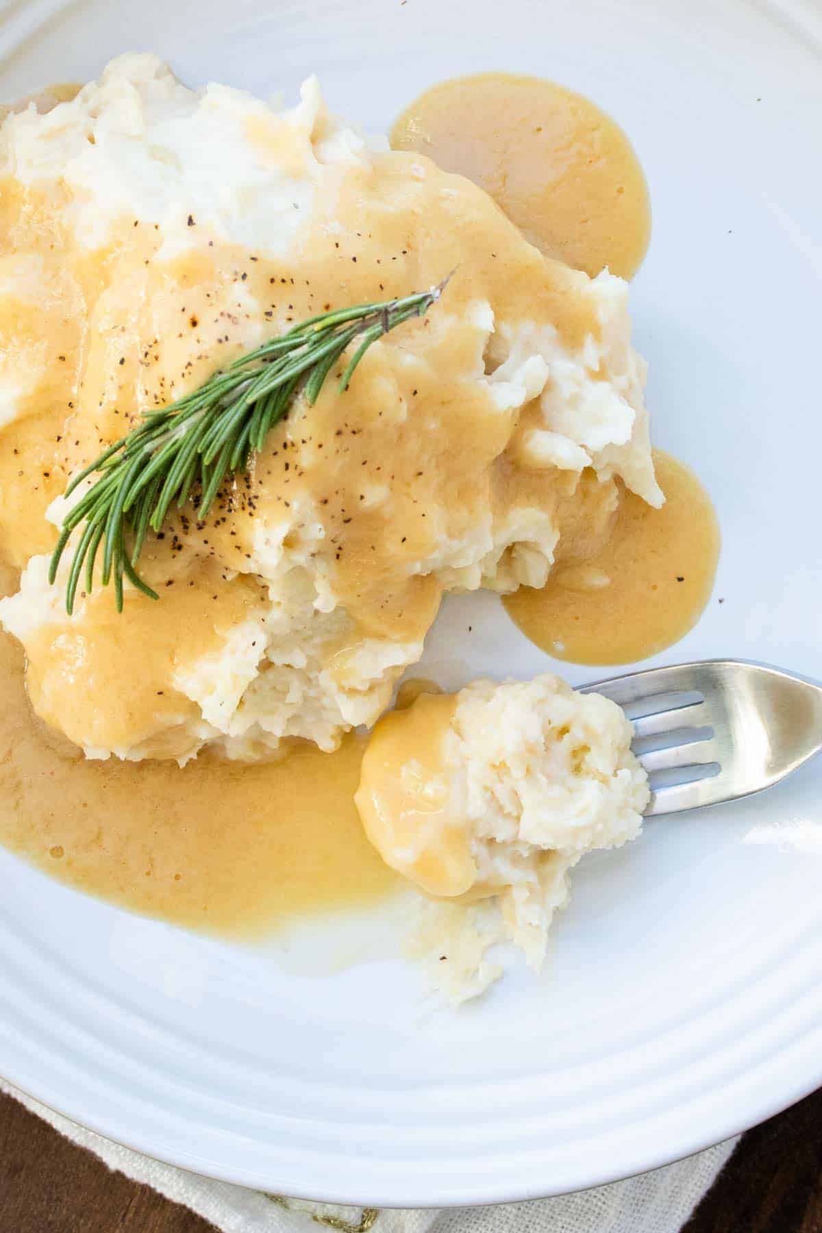 Fork getting a bite of gravy and mashed potatoes