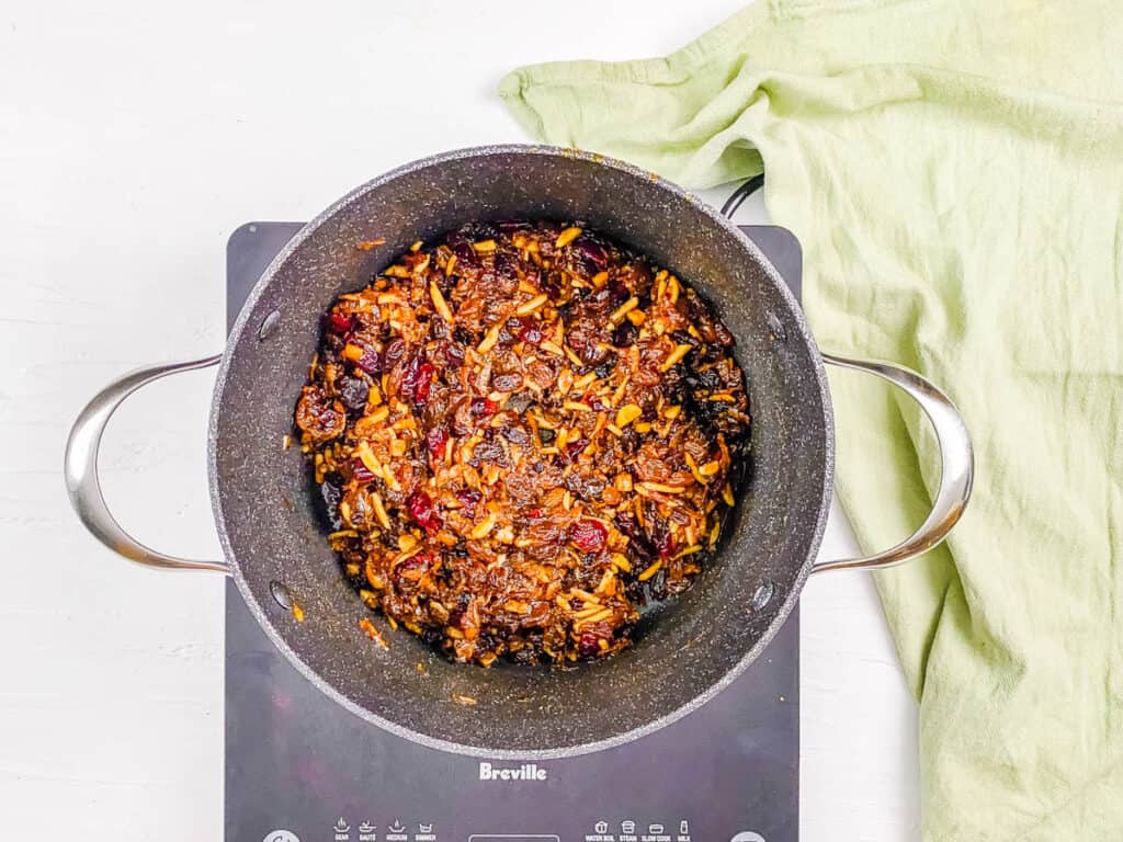 Dried fruit and spices cooking in a stock pot on the stove.