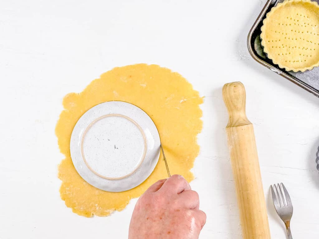 Pastry crust dough rolled out and cut into round circles for tart shells.