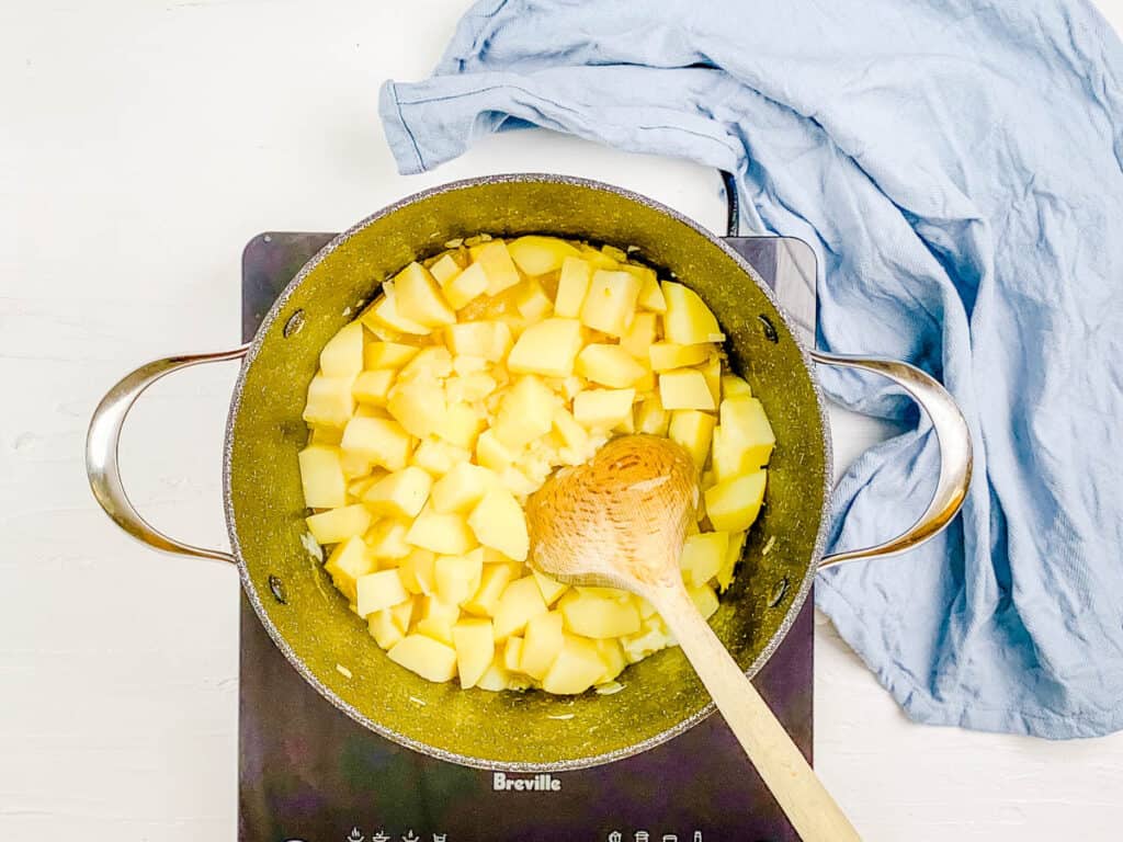 Cut potatoes and boiling water simmering in a stock pot.