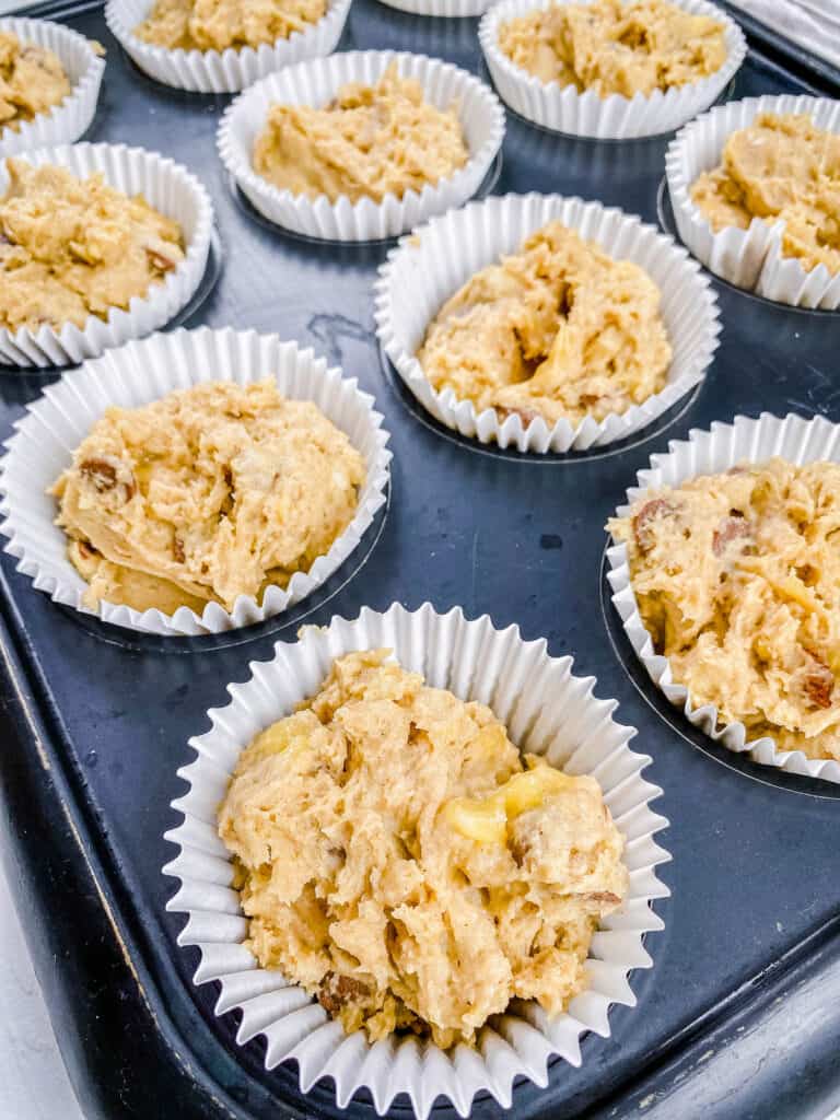 Muffin batter in muffin liners ready to be baked in the oven.