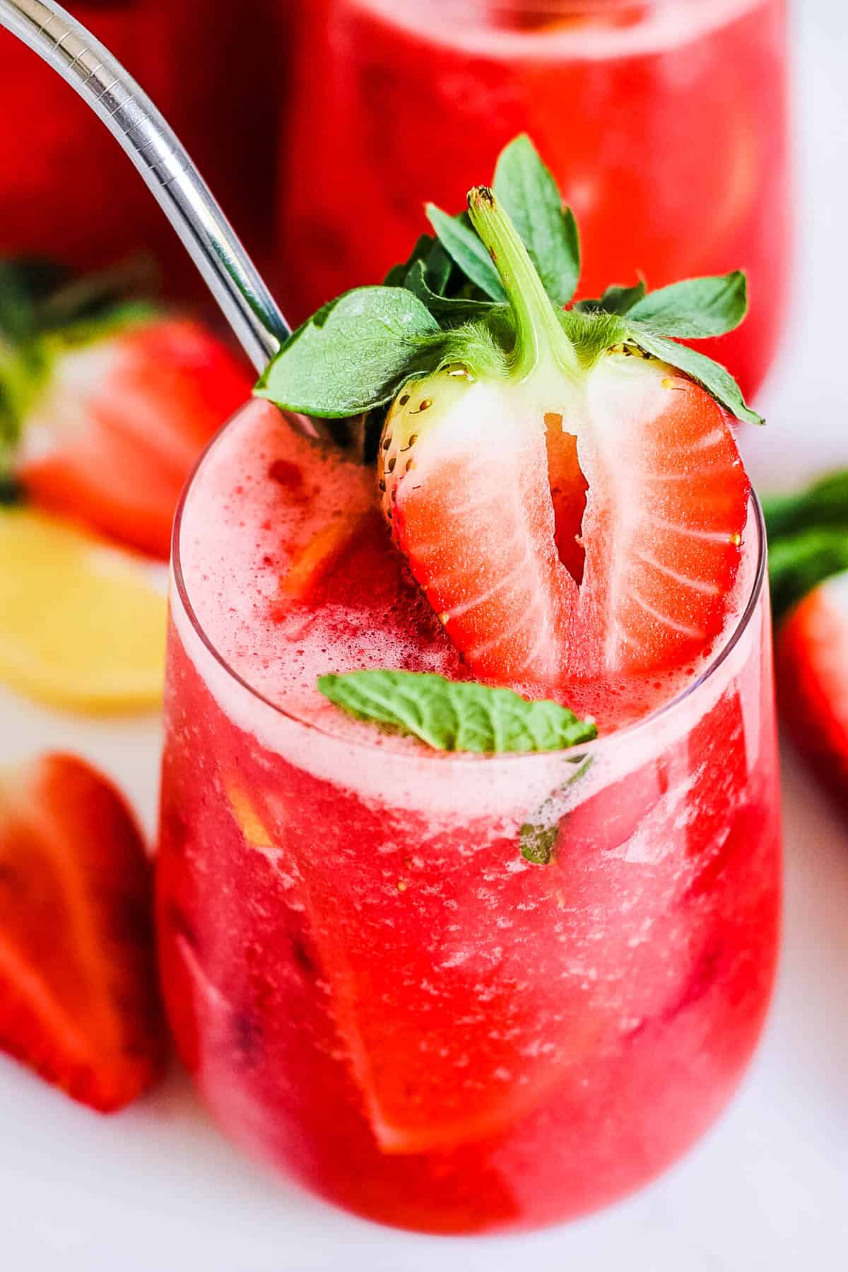 Fresh strawberry juice in a glass with a straw.