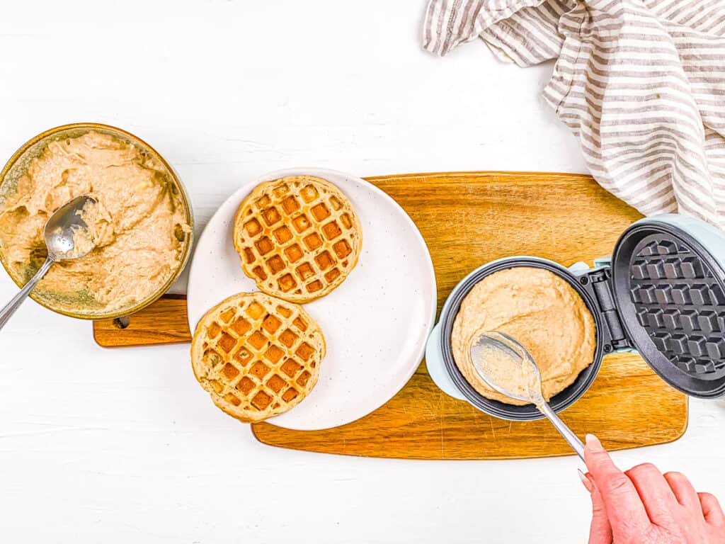 High protein vegan waffles stacked on a white plate.