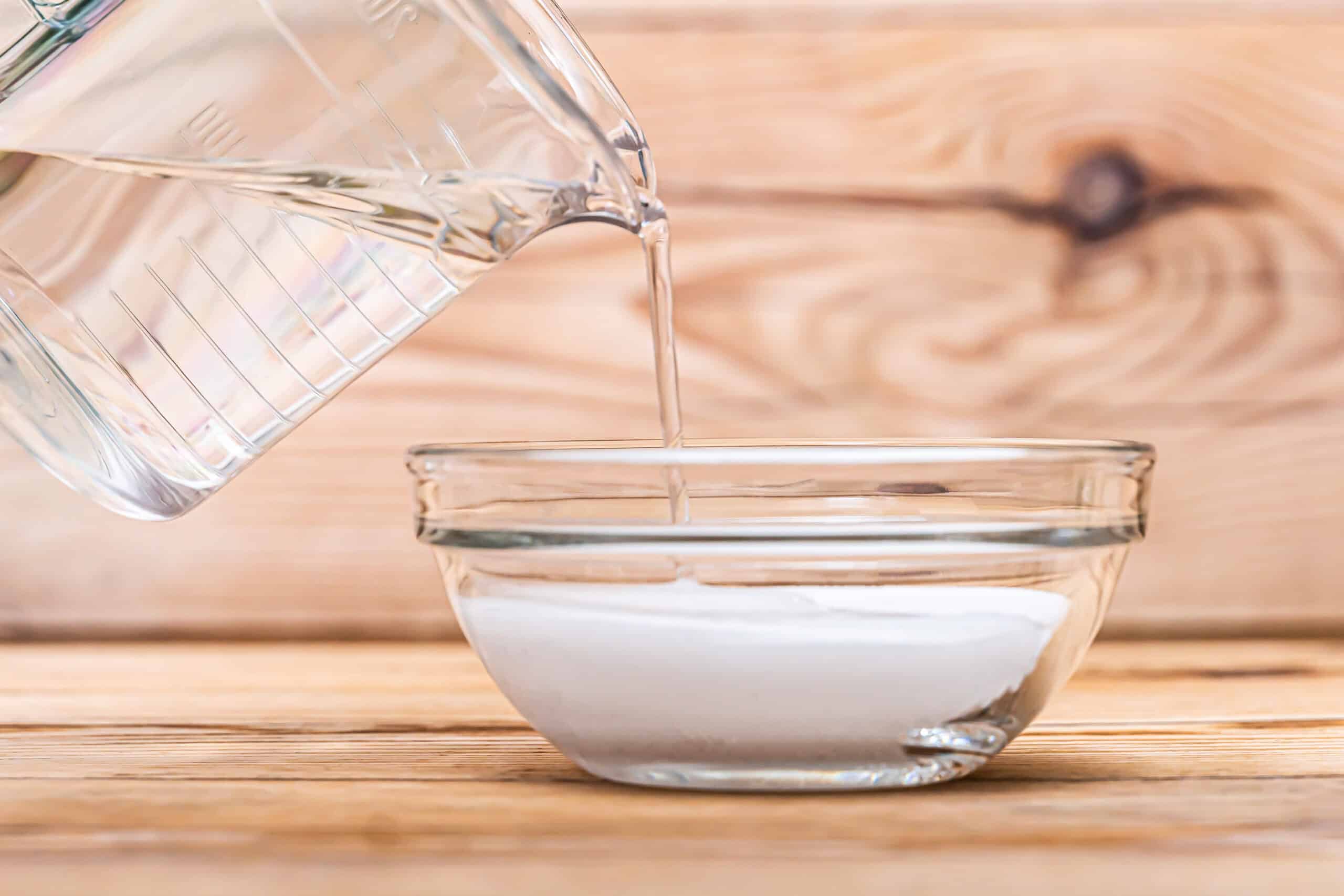 Water being poured from measuring cup into bowl.