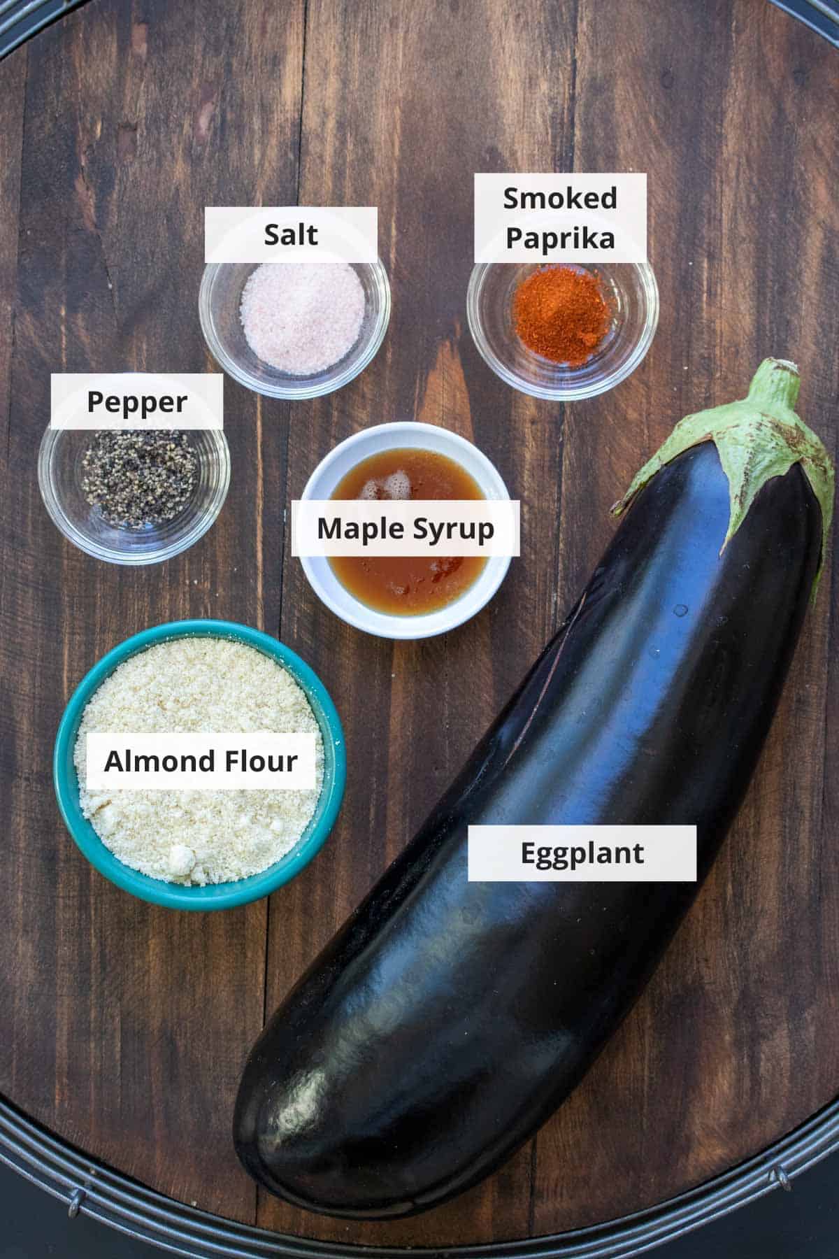 Ingredients for vegan eggplant fries recipe on a wood background.