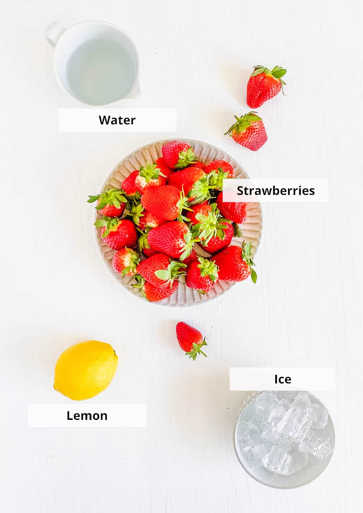 Ingredients for strawberry juice recipe on a white background.