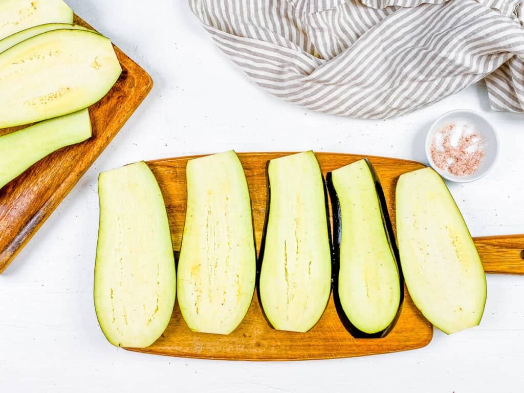 Sliced eggplant on a cutting board.