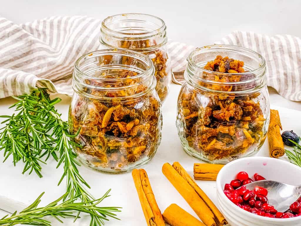 Vegetarian mincemeat in glass jars with holiday decoration around them.