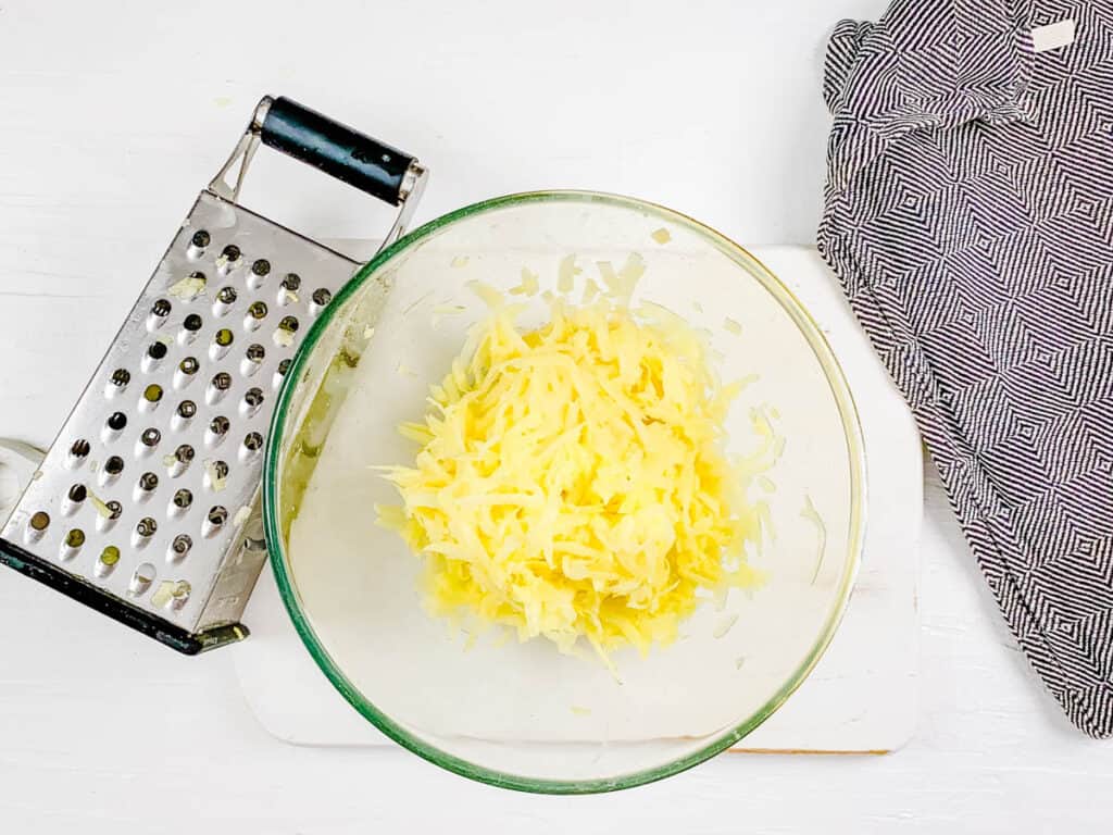 Shredded potatoes in a mixing bowl.