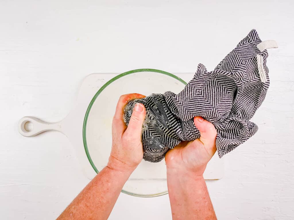 Πατάτες στυμμένες με μια πετσέτα πιάτων για να αφαιρέσετε την υπερβολική υγρασία.