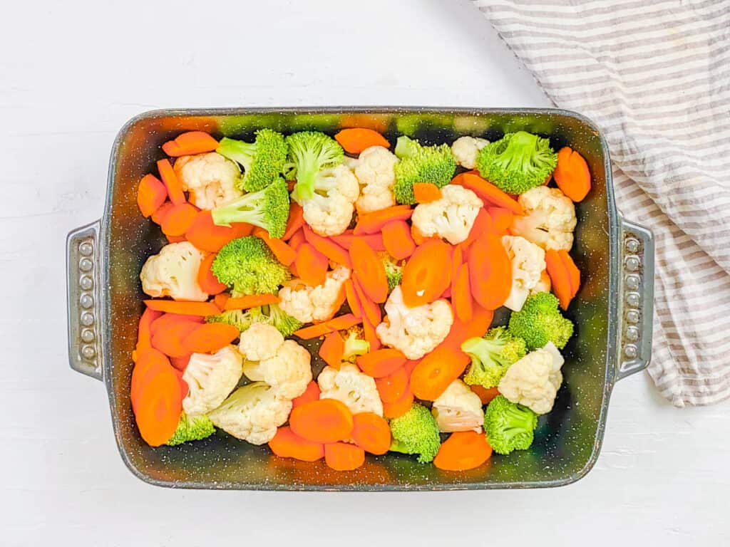 Cut broccoli, cauliflower and carrots in a baking dish.
