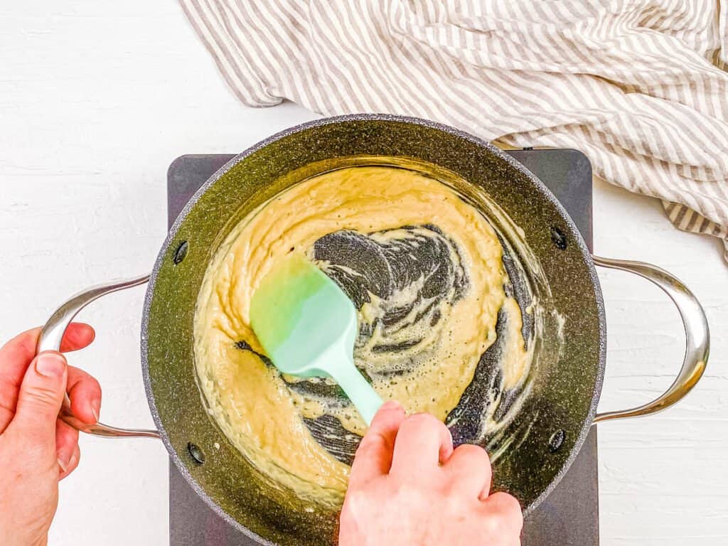 Vegan bechamel sauce cooking in a pot.