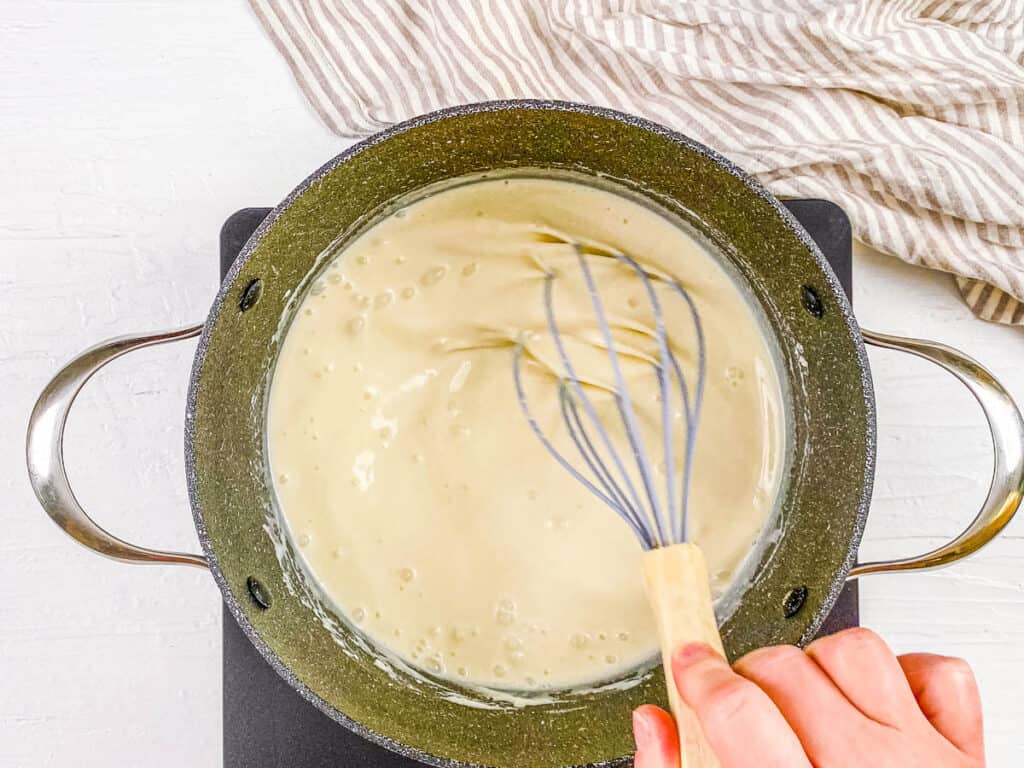 Vegan bechamel sauce cooking in a pot.