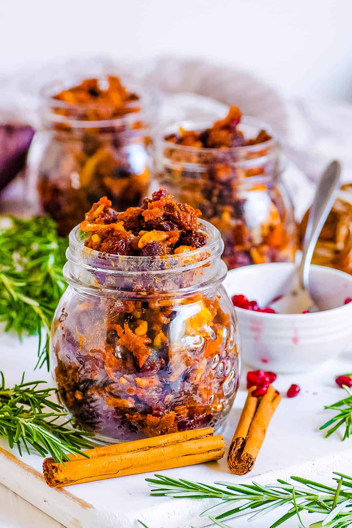 Vegan mincemeat in glass jars with holiday decorations surrounding the jars.