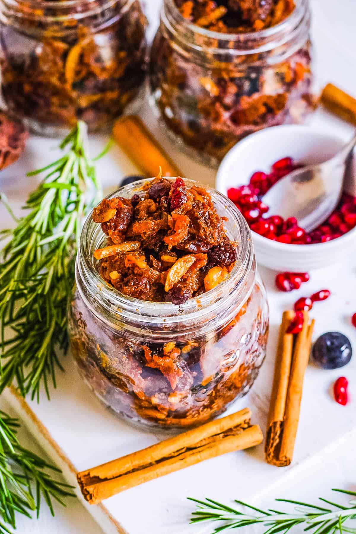 Vegan mincemeat in gl، jars with ،liday decorations surrounding the jars.