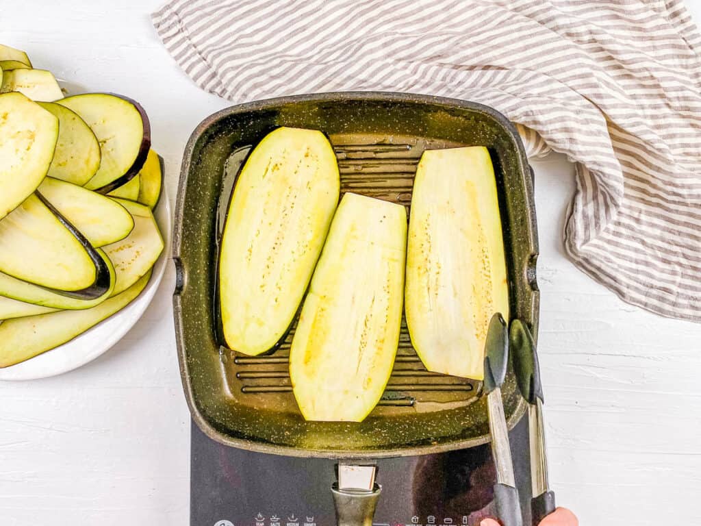 Eggplant slices grilled on a grill pan.