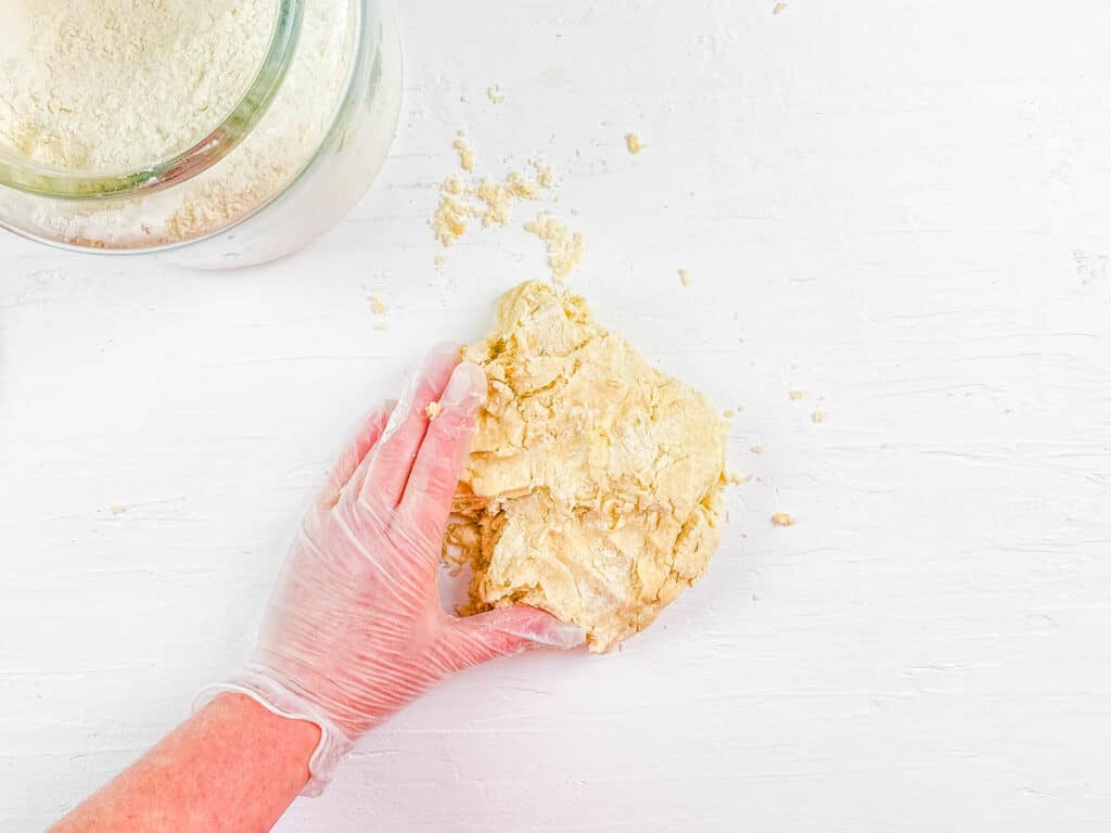 Dough for homemade naan being kneaded on a work surface.