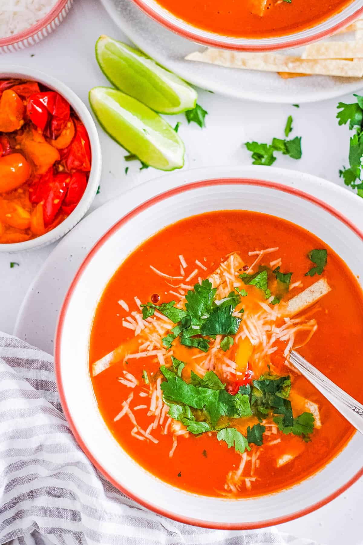 Healthy vegetarian taco soup topped with cilantro and cheese in a white bowl.