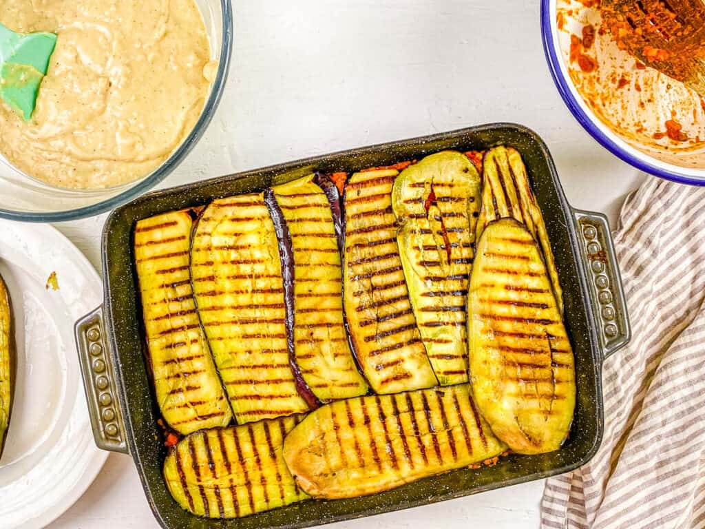 Eggplant slices layered in a baking dish.