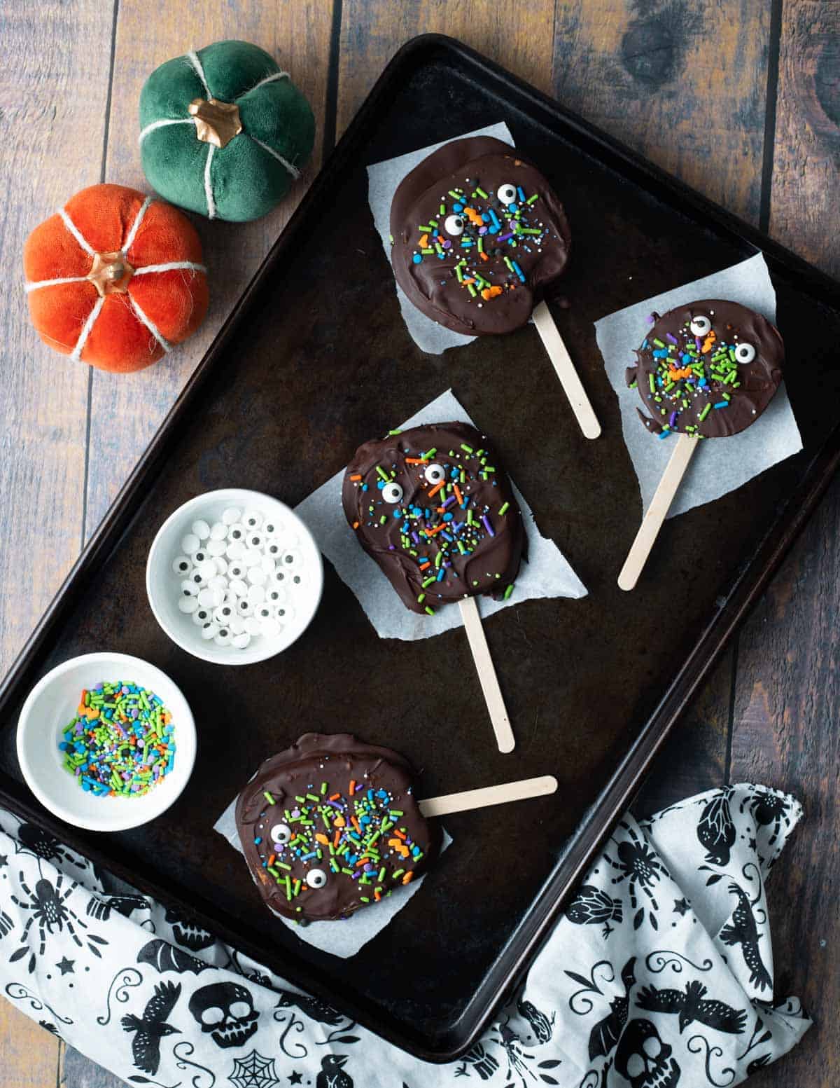 Chocolate Halloween apple slices on baking tray.