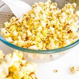 Pressure cooker popcorn mixed with seasonings in a glass bowl.