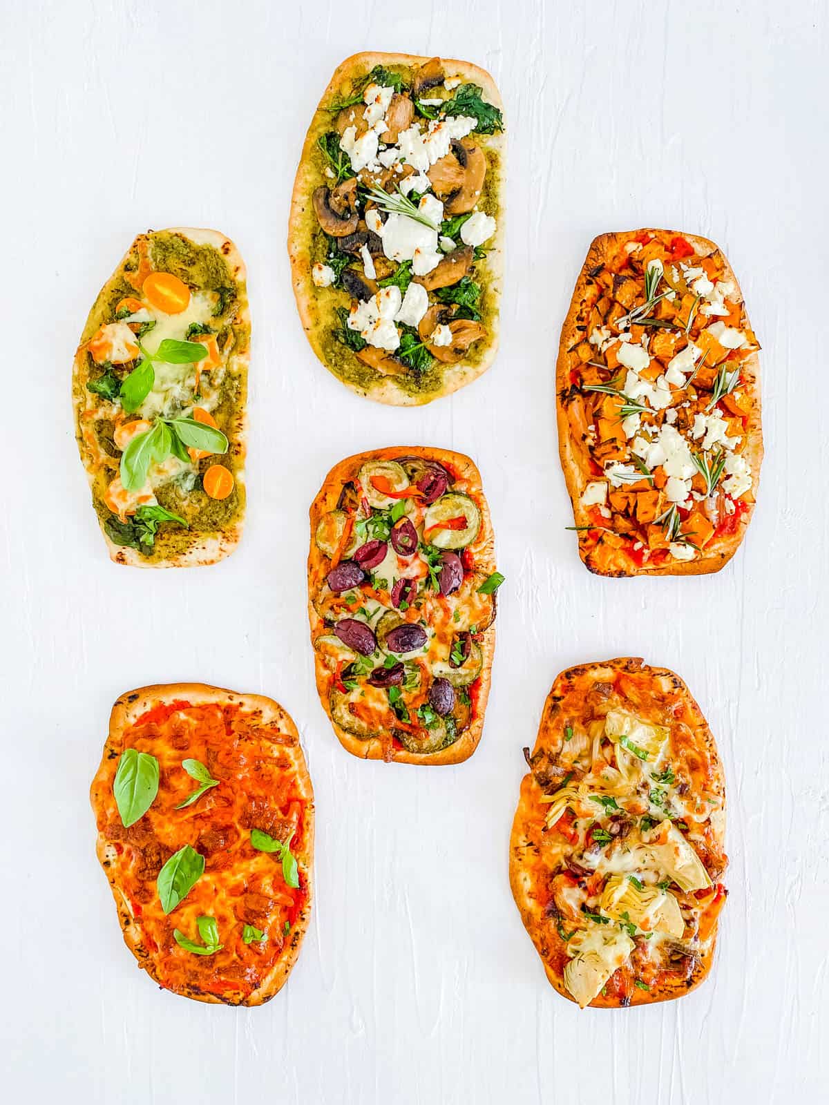 Variety of naan bread pizza recipes with different toppings on a white background.