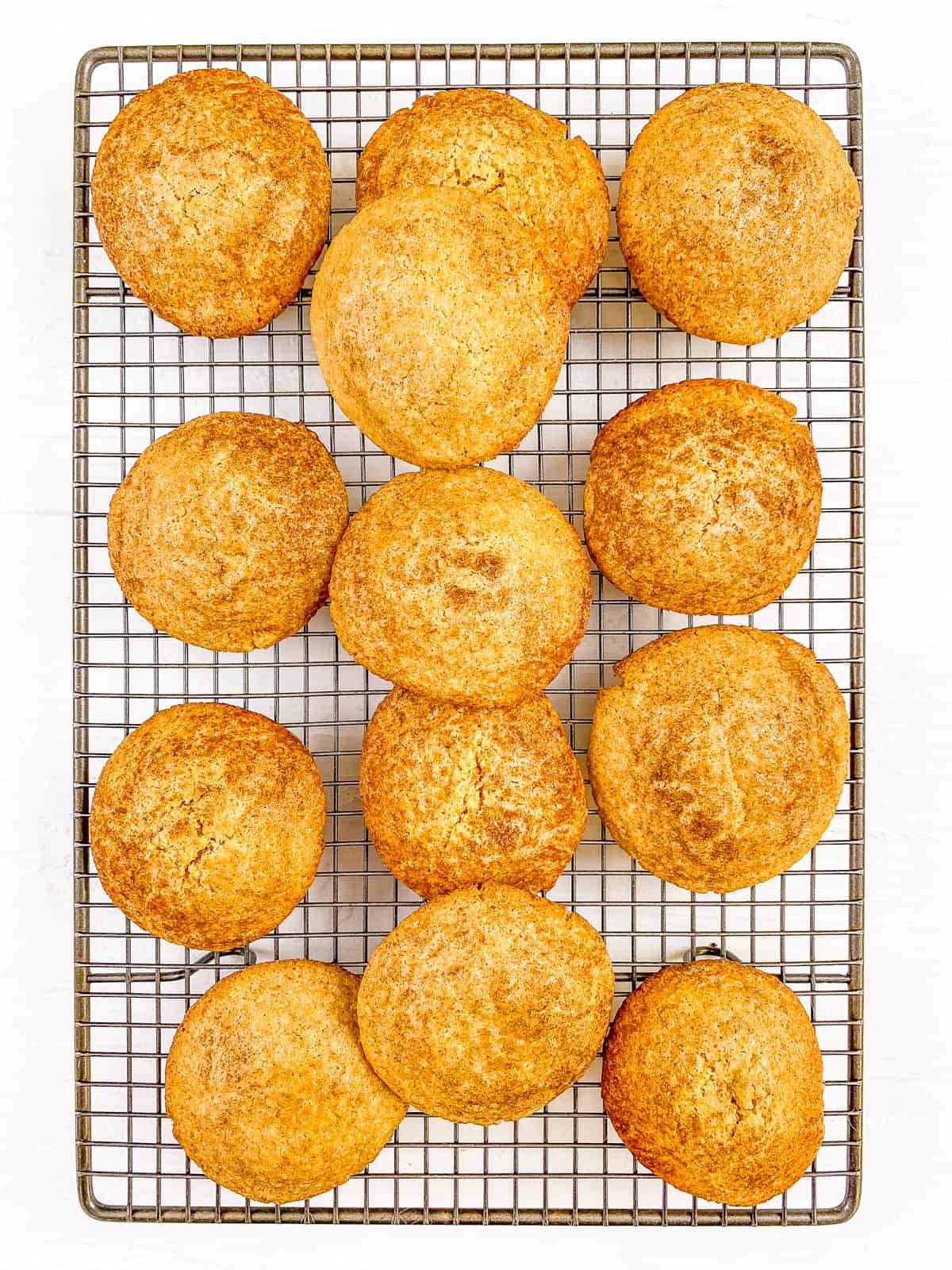 Snickerdoodles without cream of tartar stacked on a wire rack.