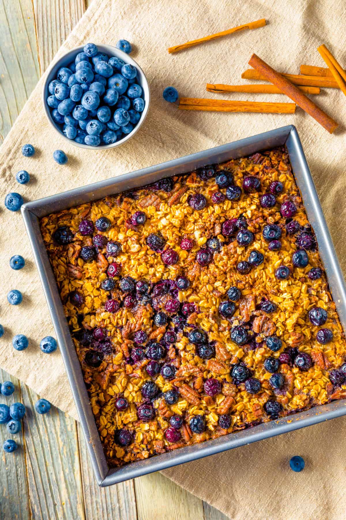 An overhead shot of pan of vegan baked oatmeal with blueberries and cinnamon.