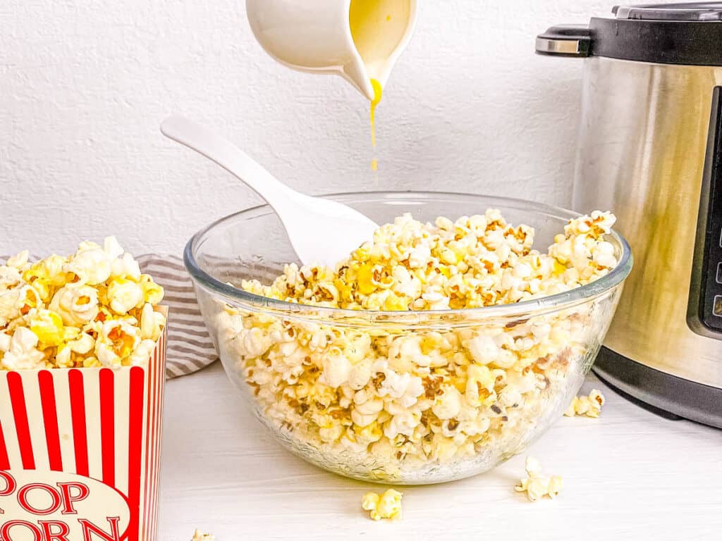 Pressure cooker popcorn mixed with seasonings in a glass bowl.