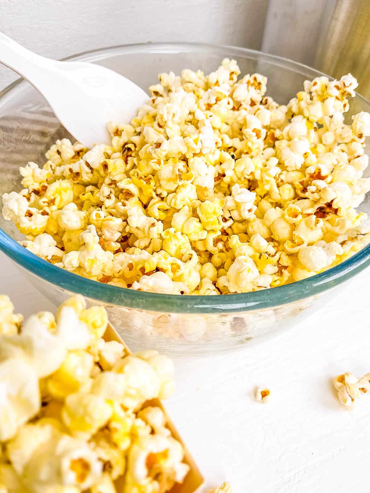 Pressure cooker popcorn mixed with seasonings in a glass bowl.