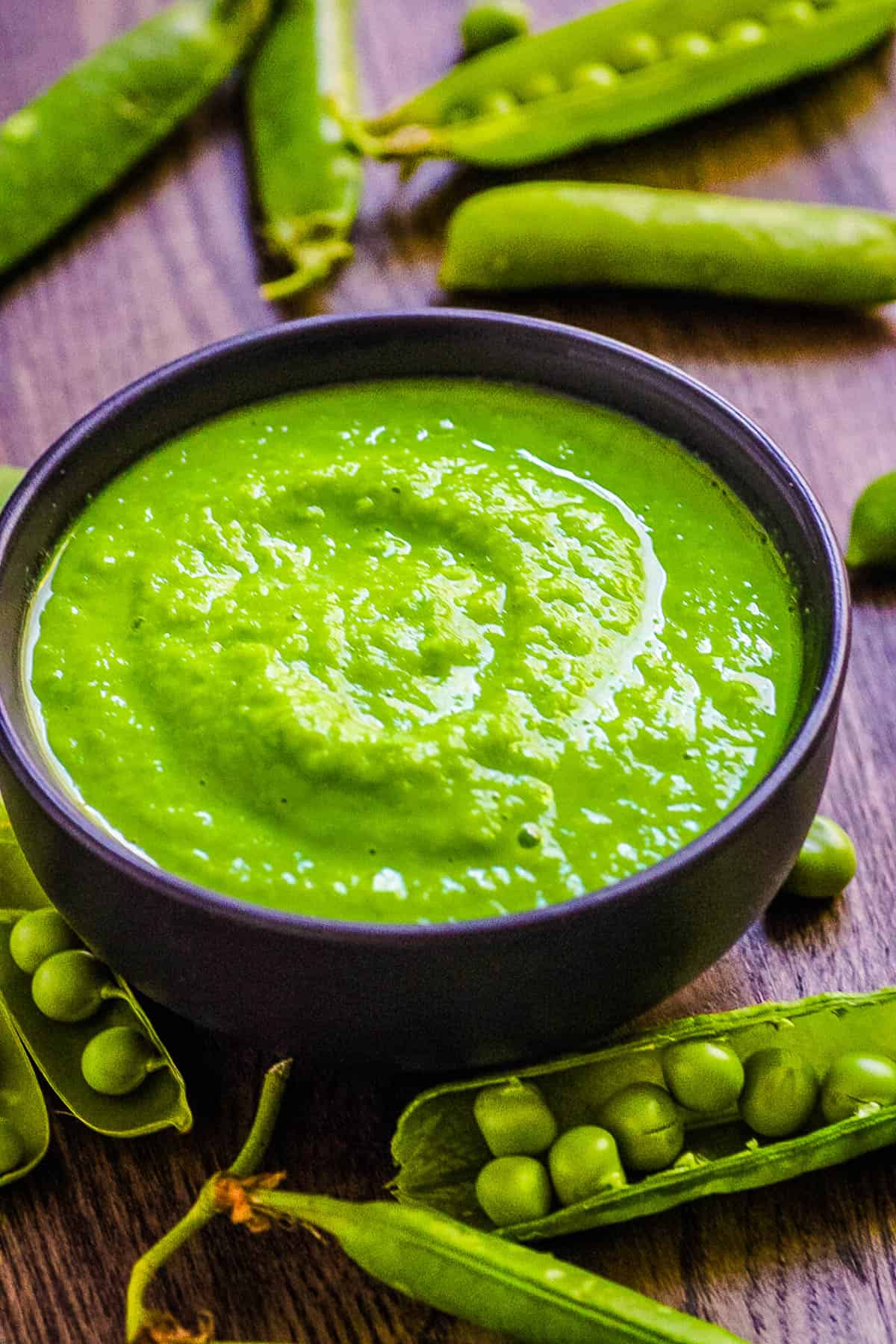 Pea puree for baby in a black serving bowl.