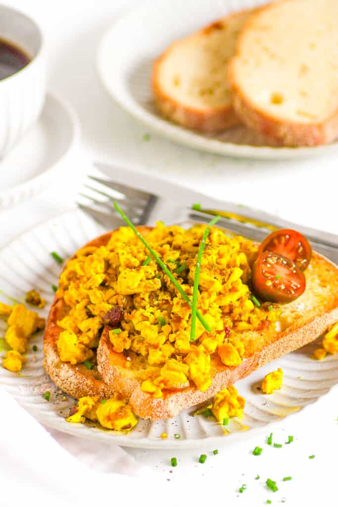 Silken tofu scramble served on two slices of toast on a white plate.