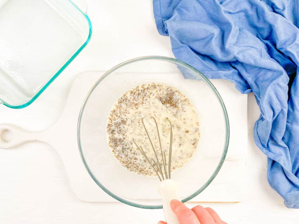 Chia seed, water, and plant based milk mixed in a mixing bowl.