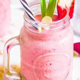 Bahama mama tropical smoothie recipe copycat in a glass mug garnished with white chocolate and strawberries.