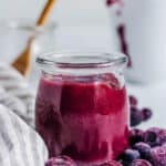 Blueberry puree for baby served in a glass jar.