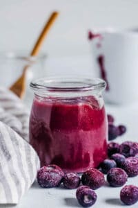 Blueberry puree for baby served in a glass jar.