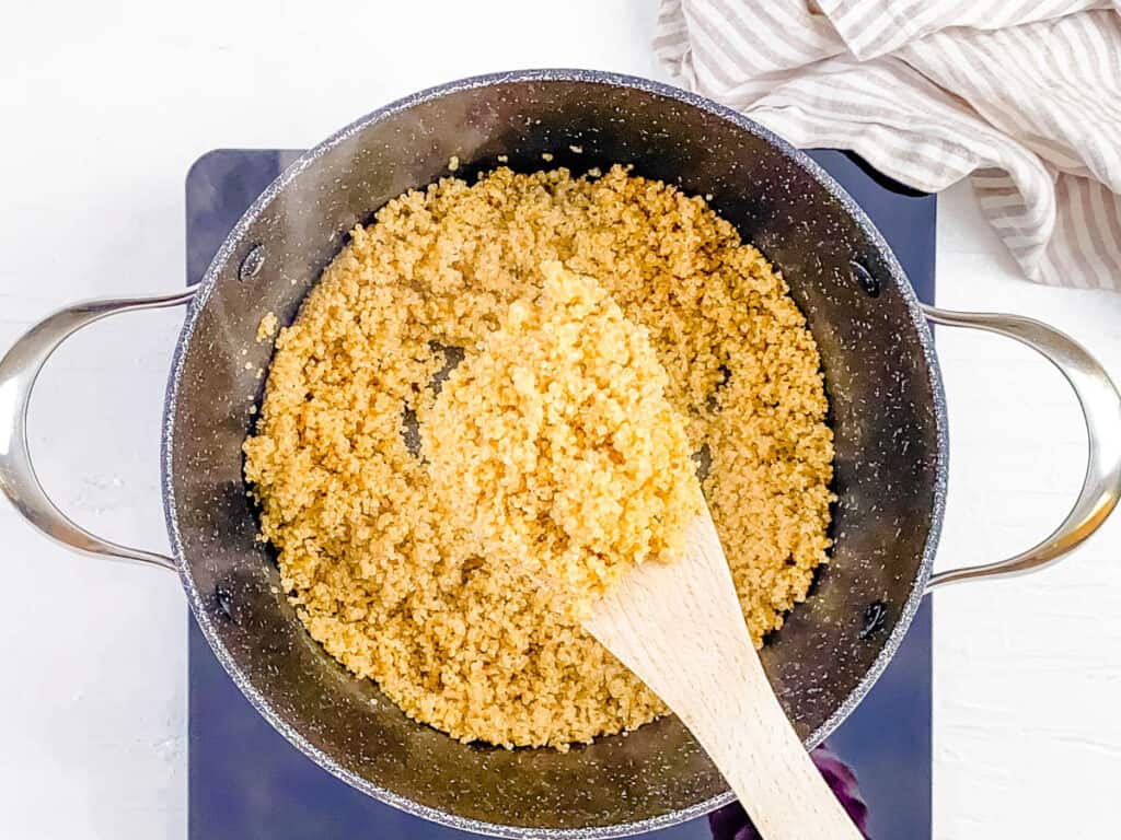 Quinoa cooking in a pot with water and milk.